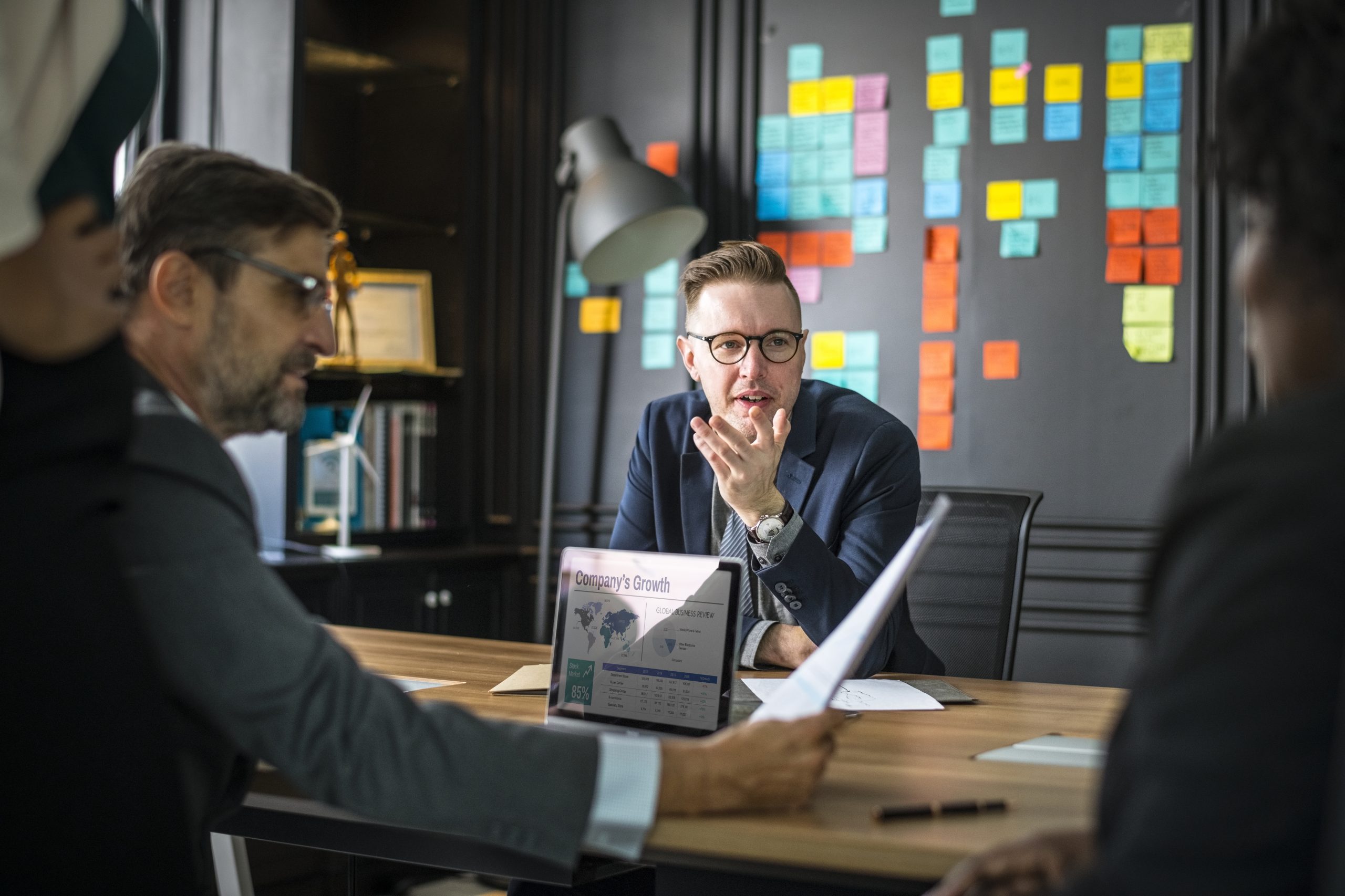 A group of business people having a meeting, probably in an agency office.