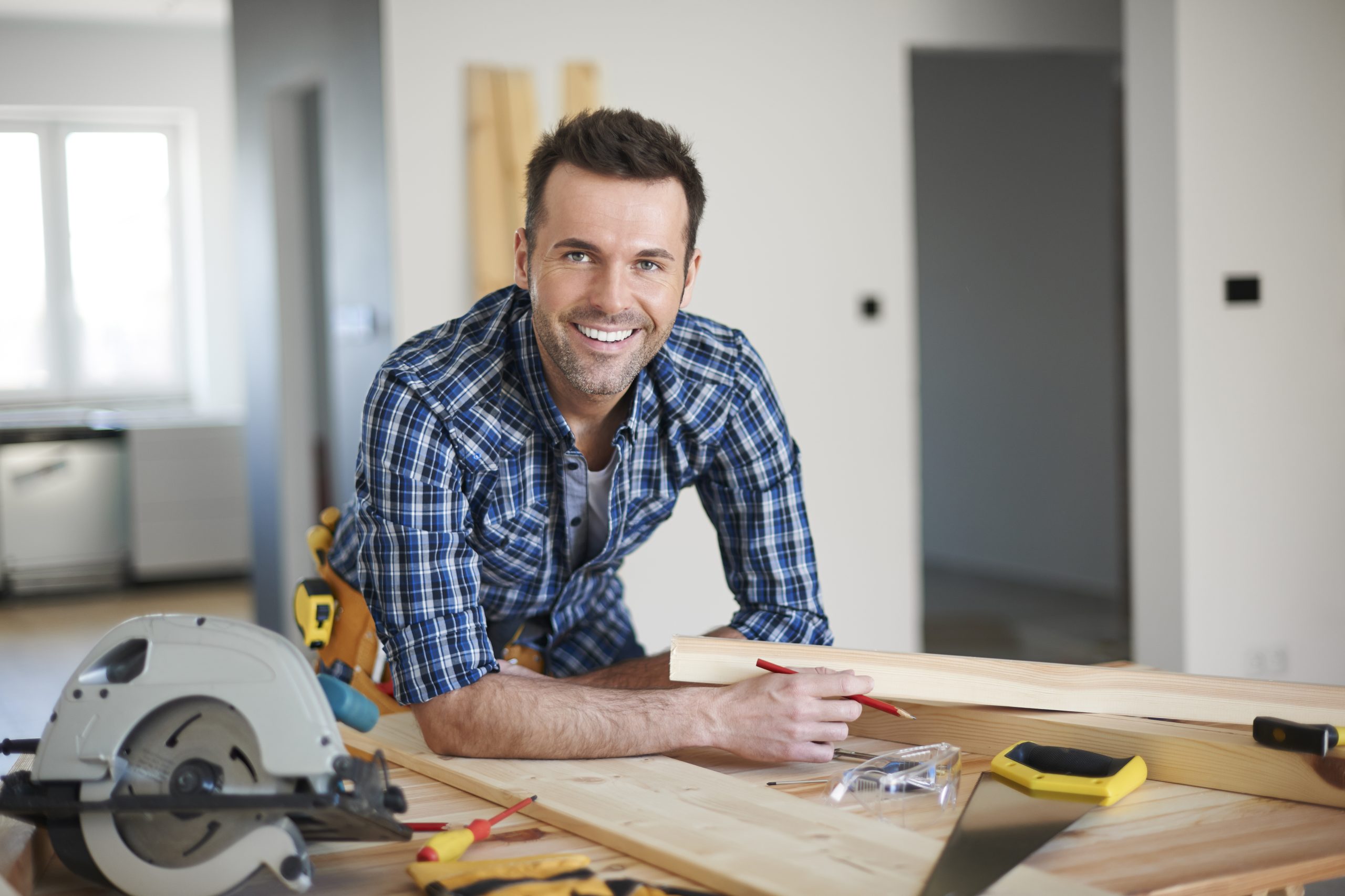 A contractor posing for a photo inside a home building