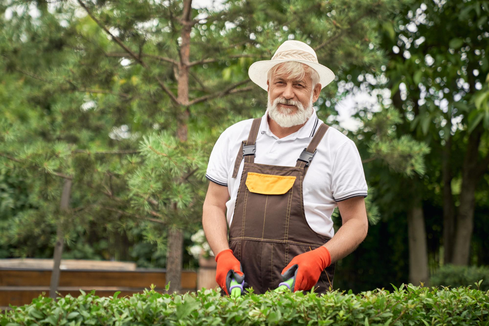 A landscaping business owner pose a shot while working in a lawn.