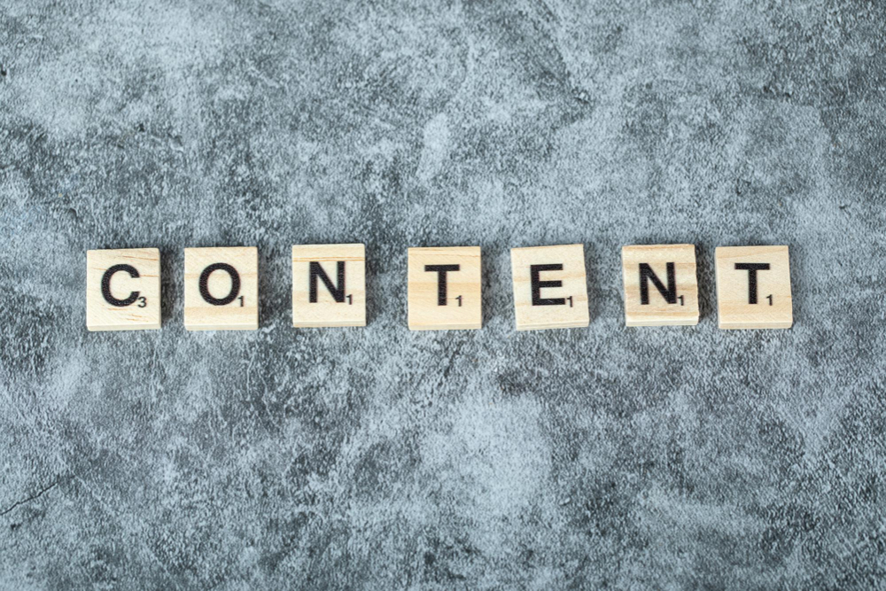 A content word written in scrabble letter, shown on a marble background, representing content for enterprise SEO marketing campaign.