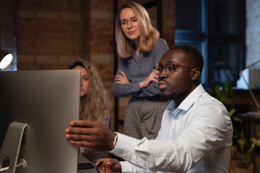 A group of marketers in casual suits, discussing about 'Boosting your enterprise SEO' campaign, inside an office space.