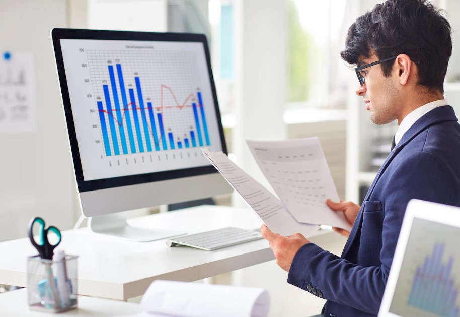 A picture of a man analysing digital marketing reports on his computer screen.