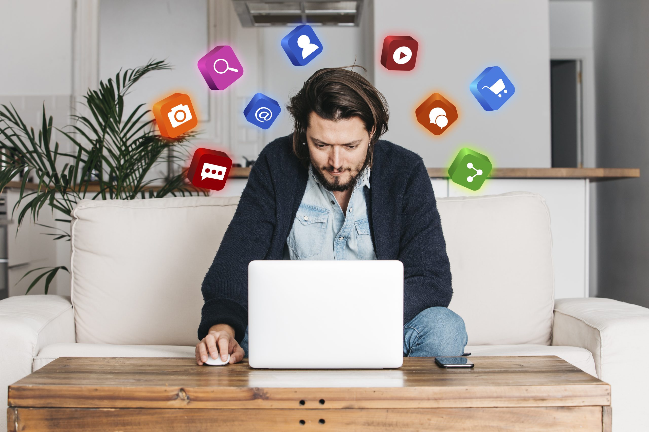 A guy working on his computer with marketing apps shown as thought bubbles on the background.