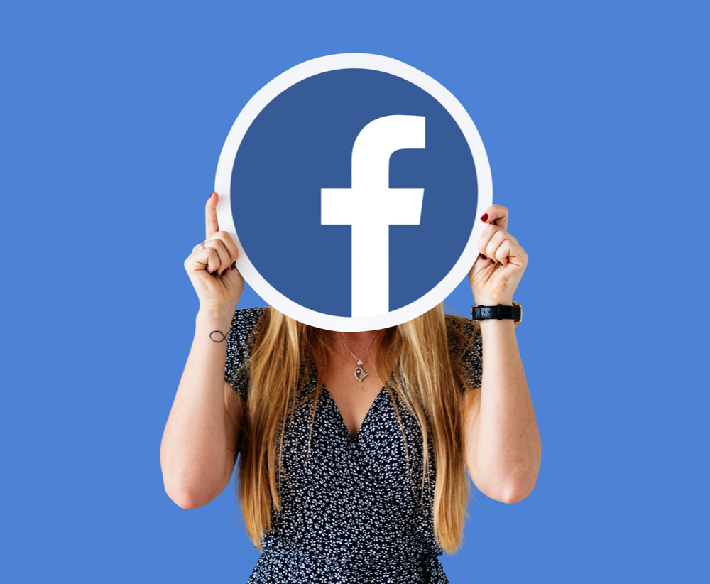 A digital marketer holding a Facebook icon.
