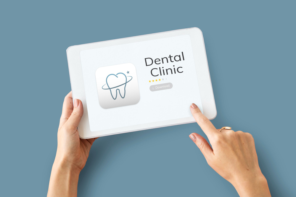 An index finger pointing to a dental clinic website app, while holding the tablet on the left hand.